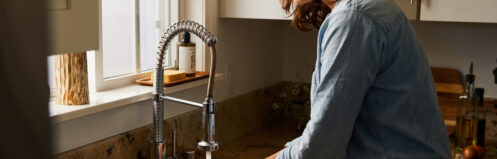 Woman washing her hands under running water in her sink
