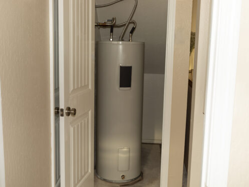 A water heater in a storage closet.